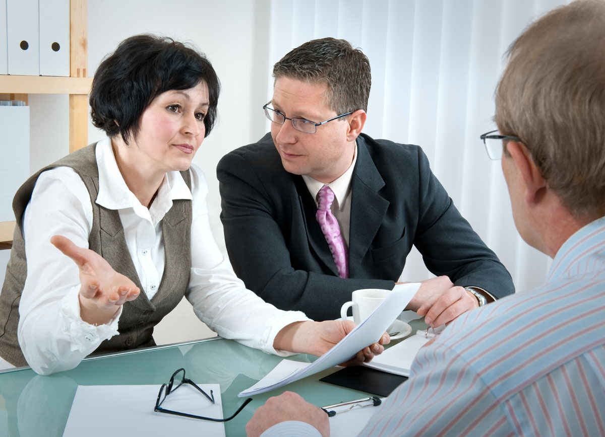 three people meeting in an office setting discussing litigation options
