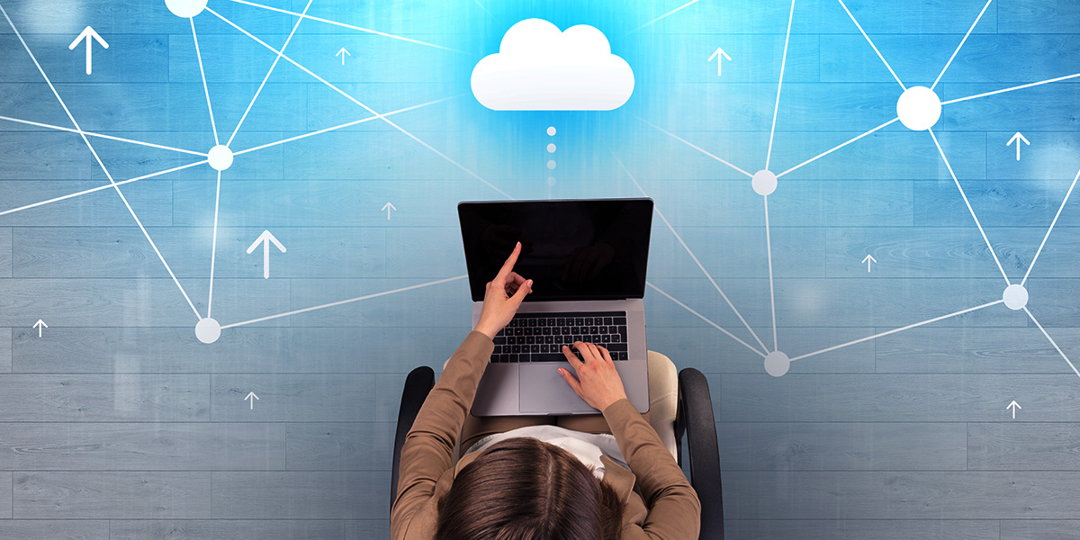person working on a laptop with icons of a cloud above it, representing the online cloud