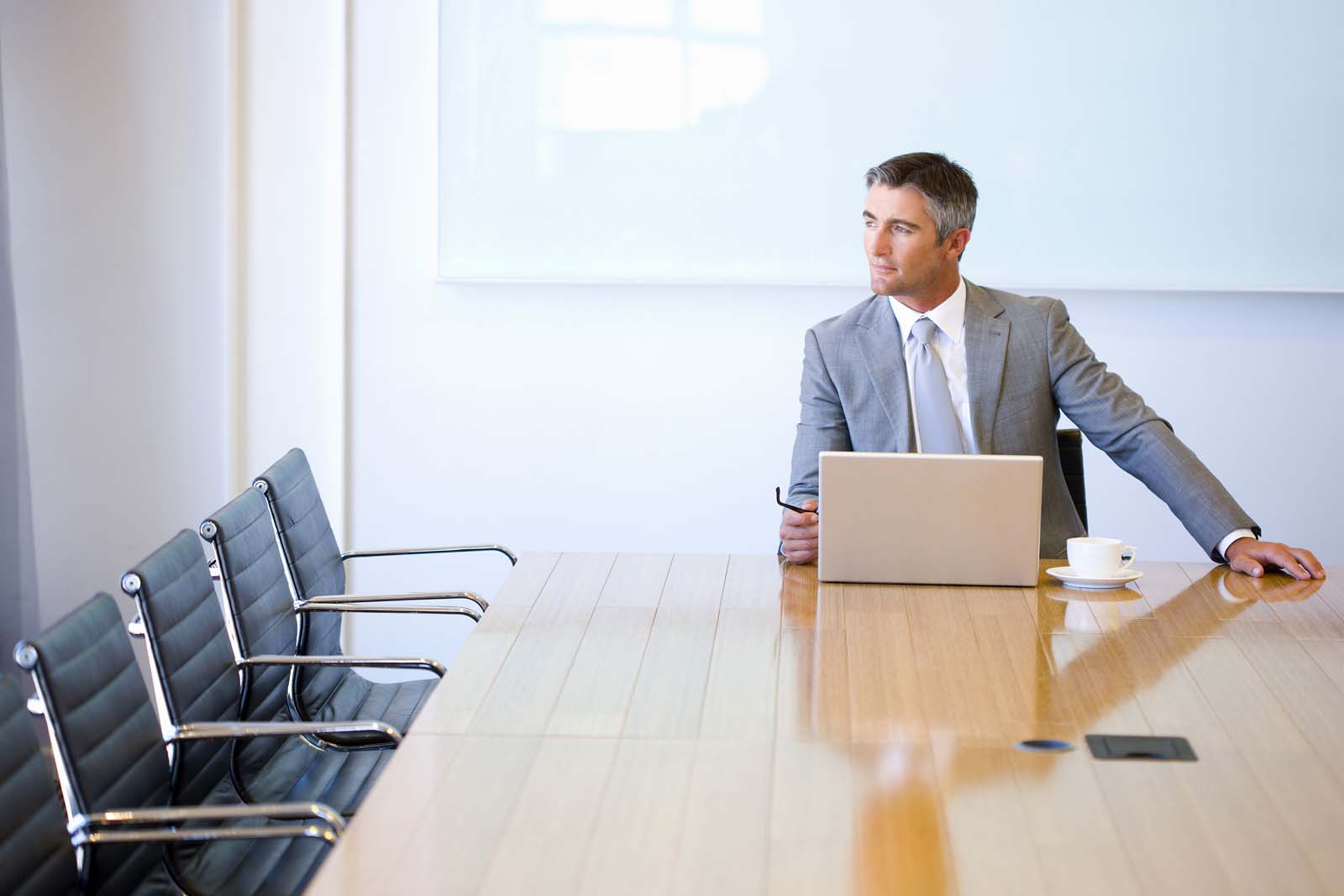 man sitting in a boardroom looking out the window