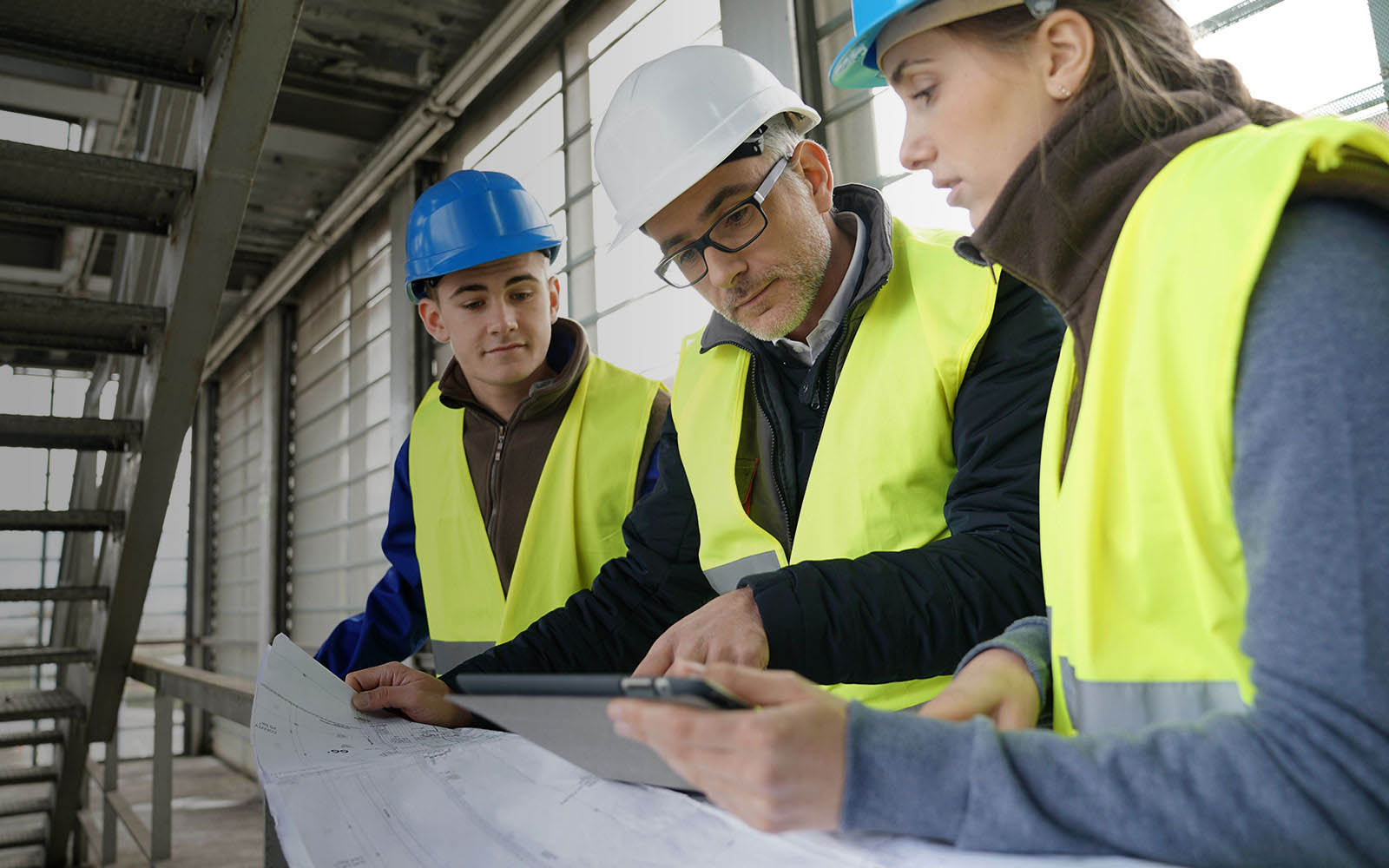 Three construction workers looking at a plan