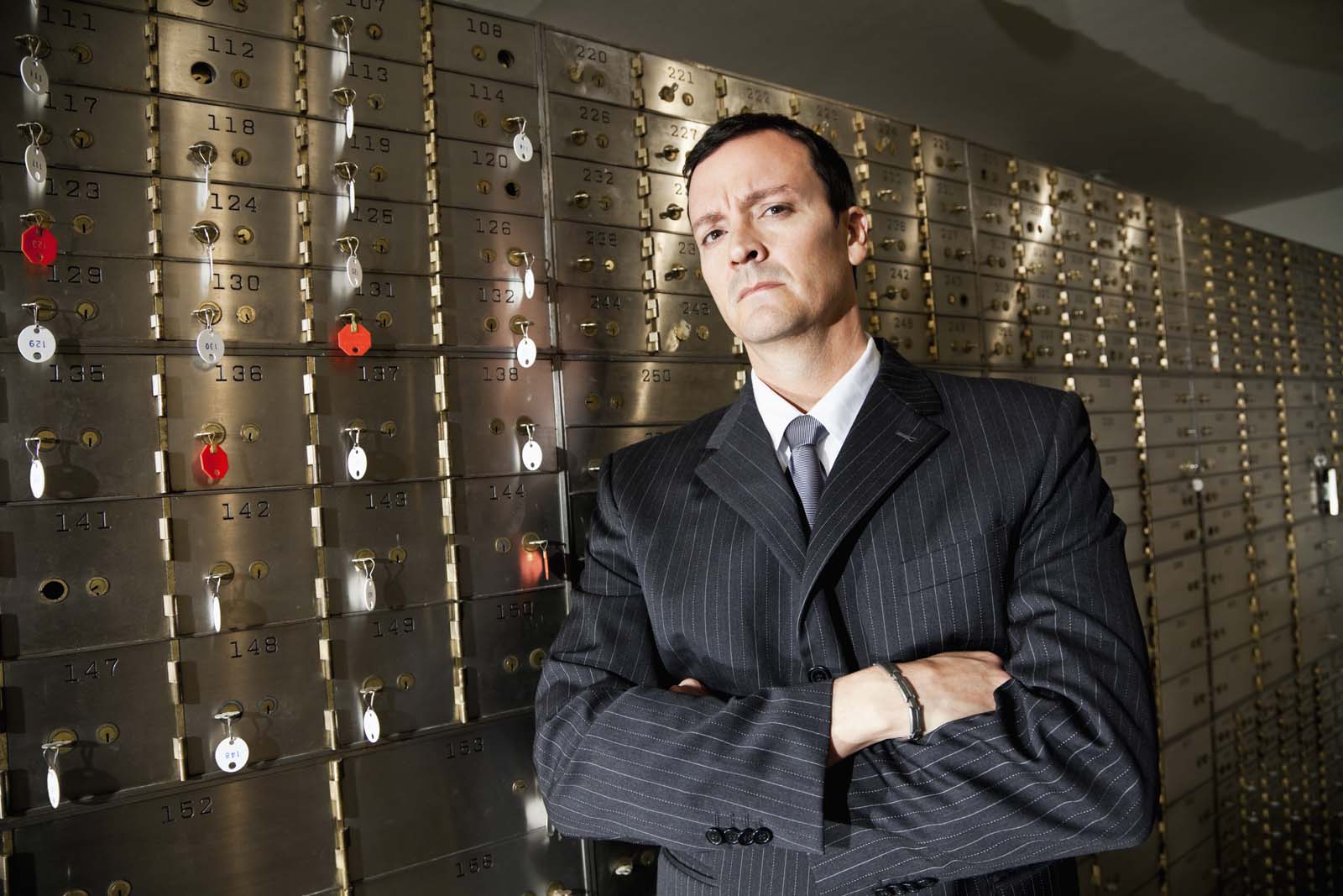 bank worker standing in front of security lock boxes