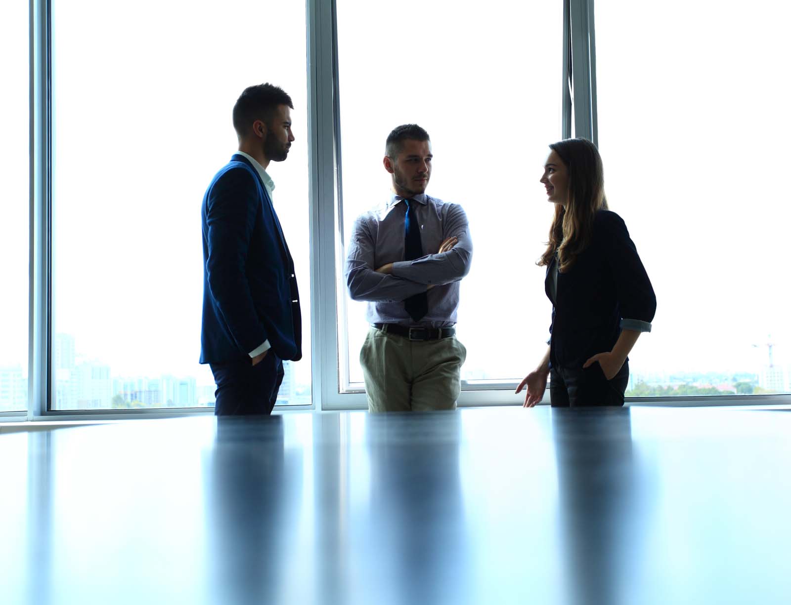 three people standing and talking 