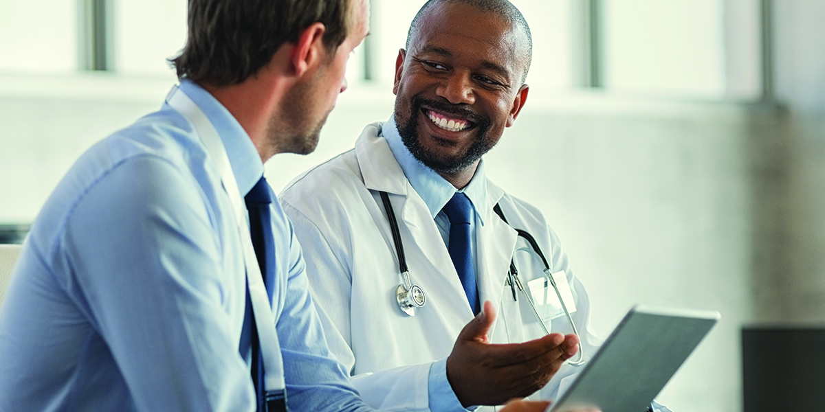 A male doctor having a conversation with a male patient