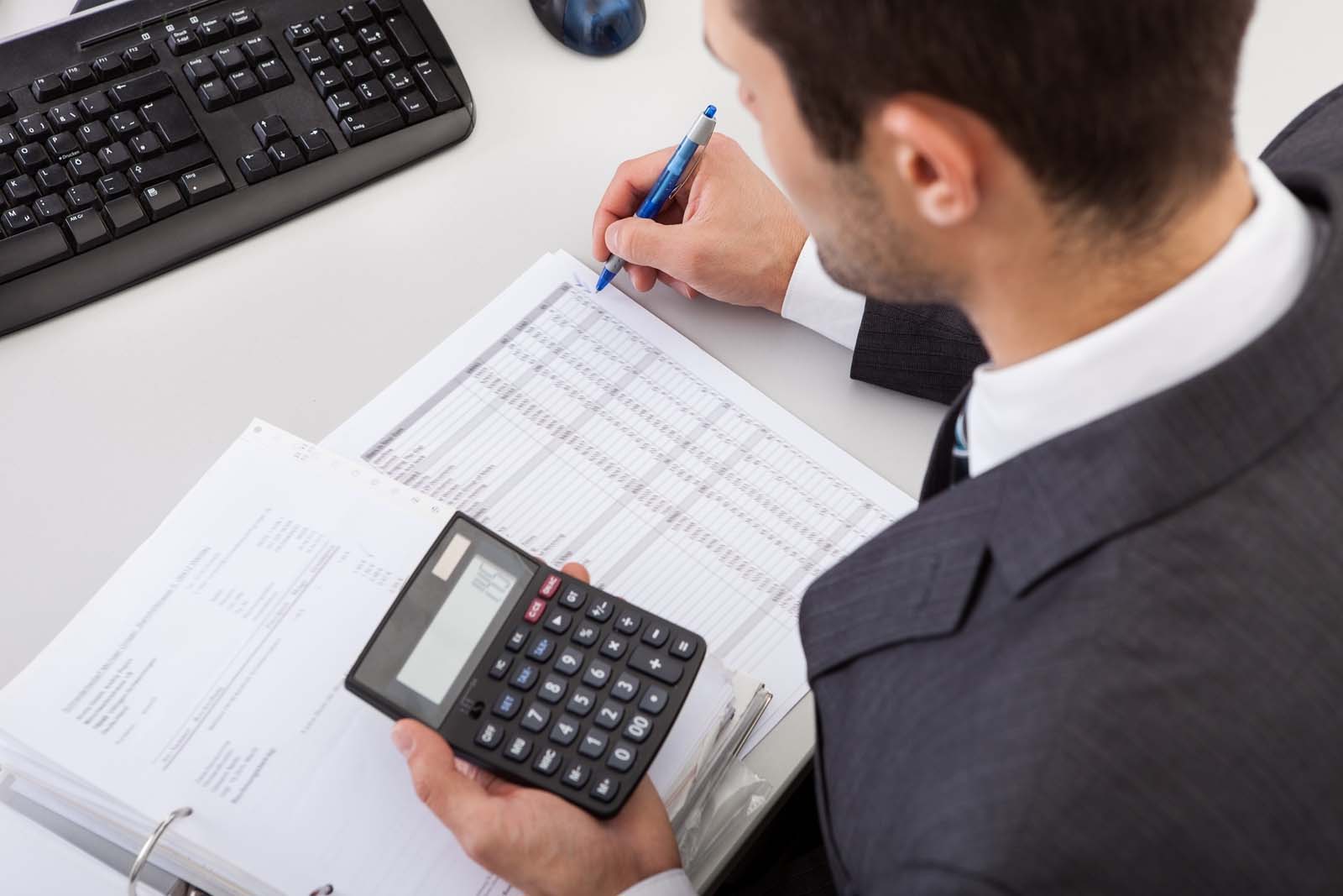 a person working at a desk using a calculator