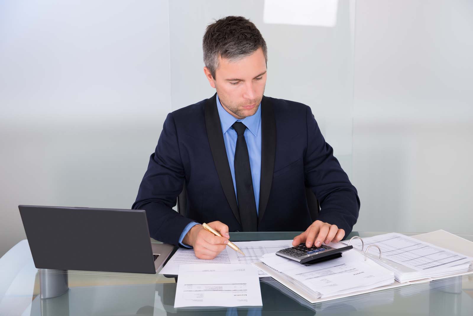 person working with papers and a laptop in an office