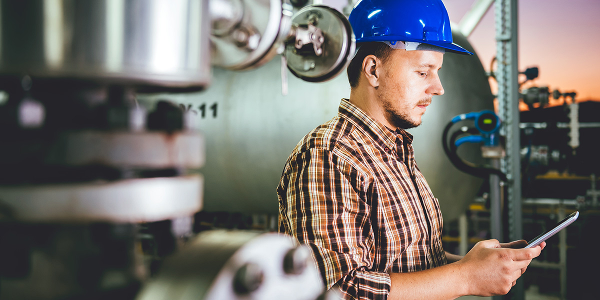 person standing in a factory in a hard hat