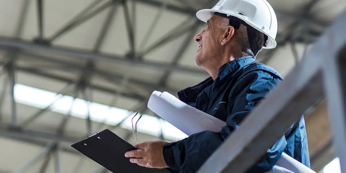 worker standing in a warehouse wearing a hard hat