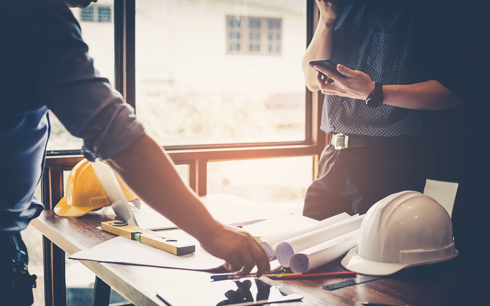 two construction workers looking at blueprints