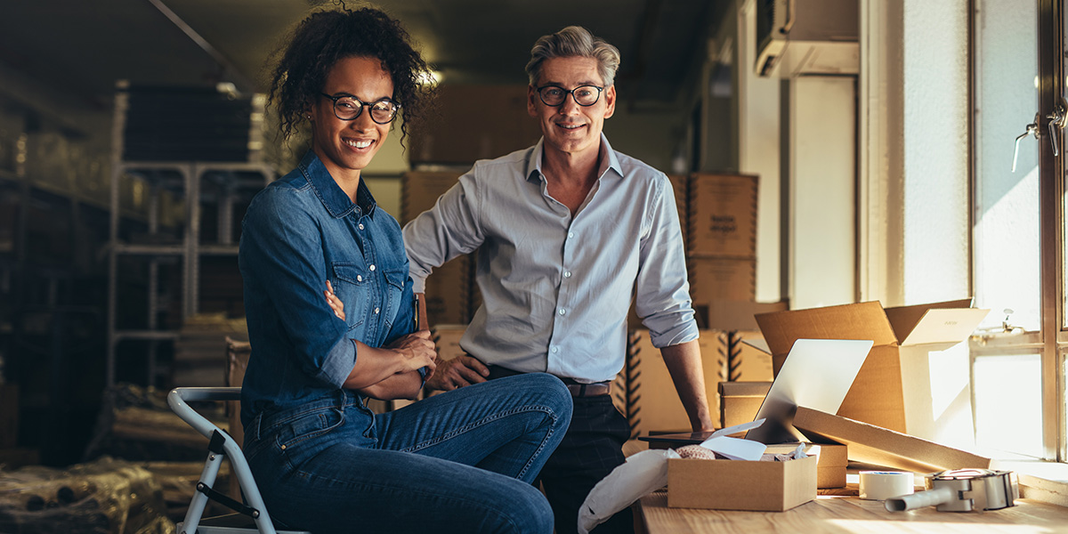 two people standing in an office together smiling