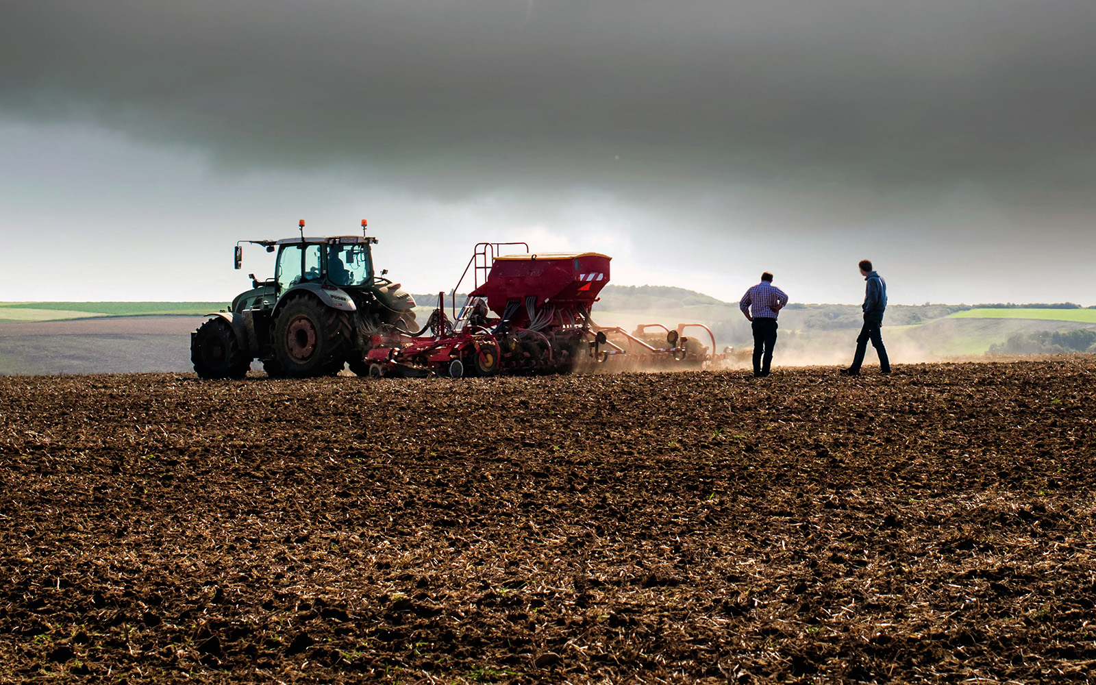 combine in field with two farmers