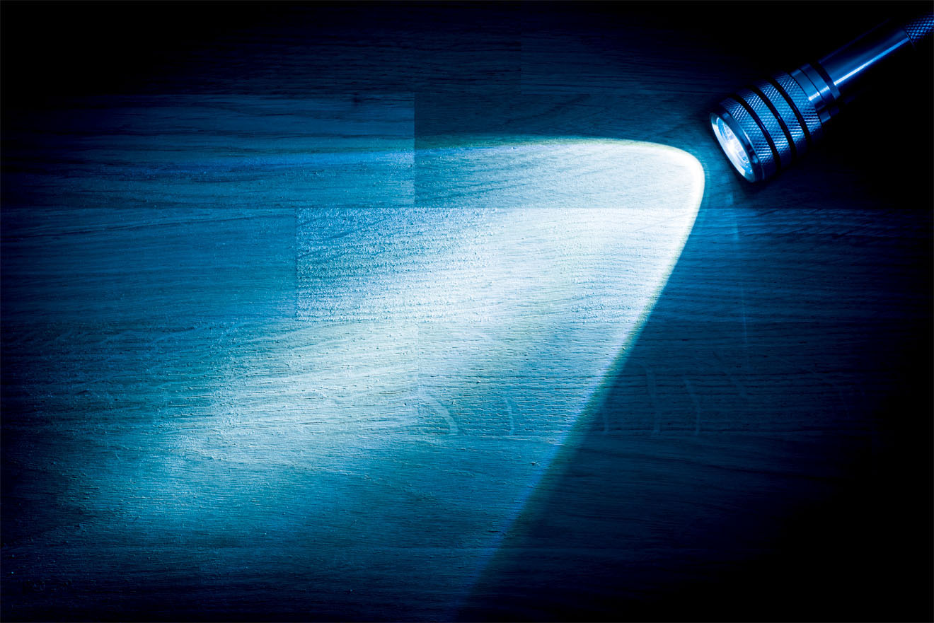 Flashlight shining onto wooden table