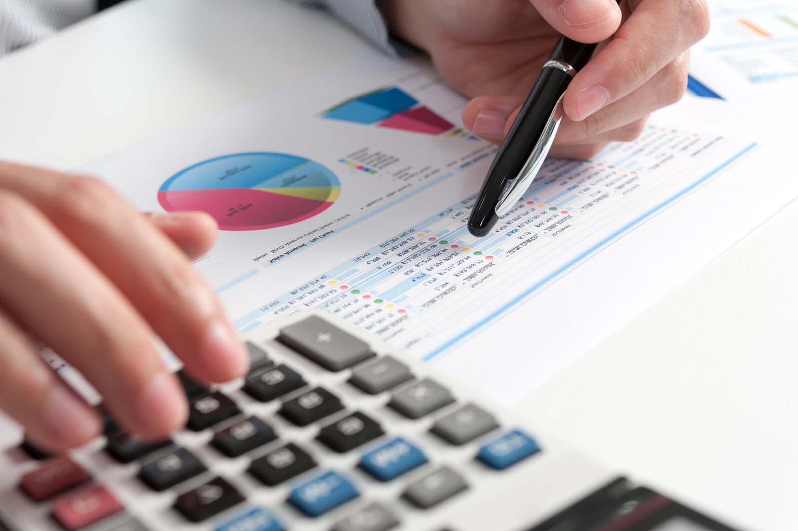 a person working on paperwork and a calculator