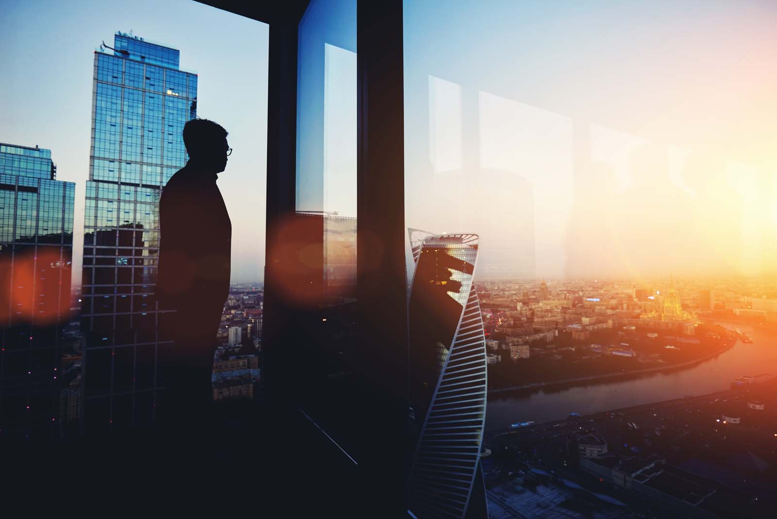 person standing in an office looking out the window