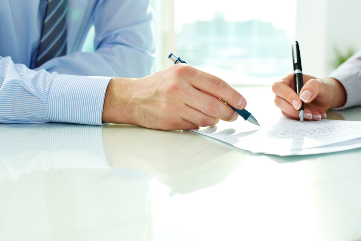 two people signing paperwork