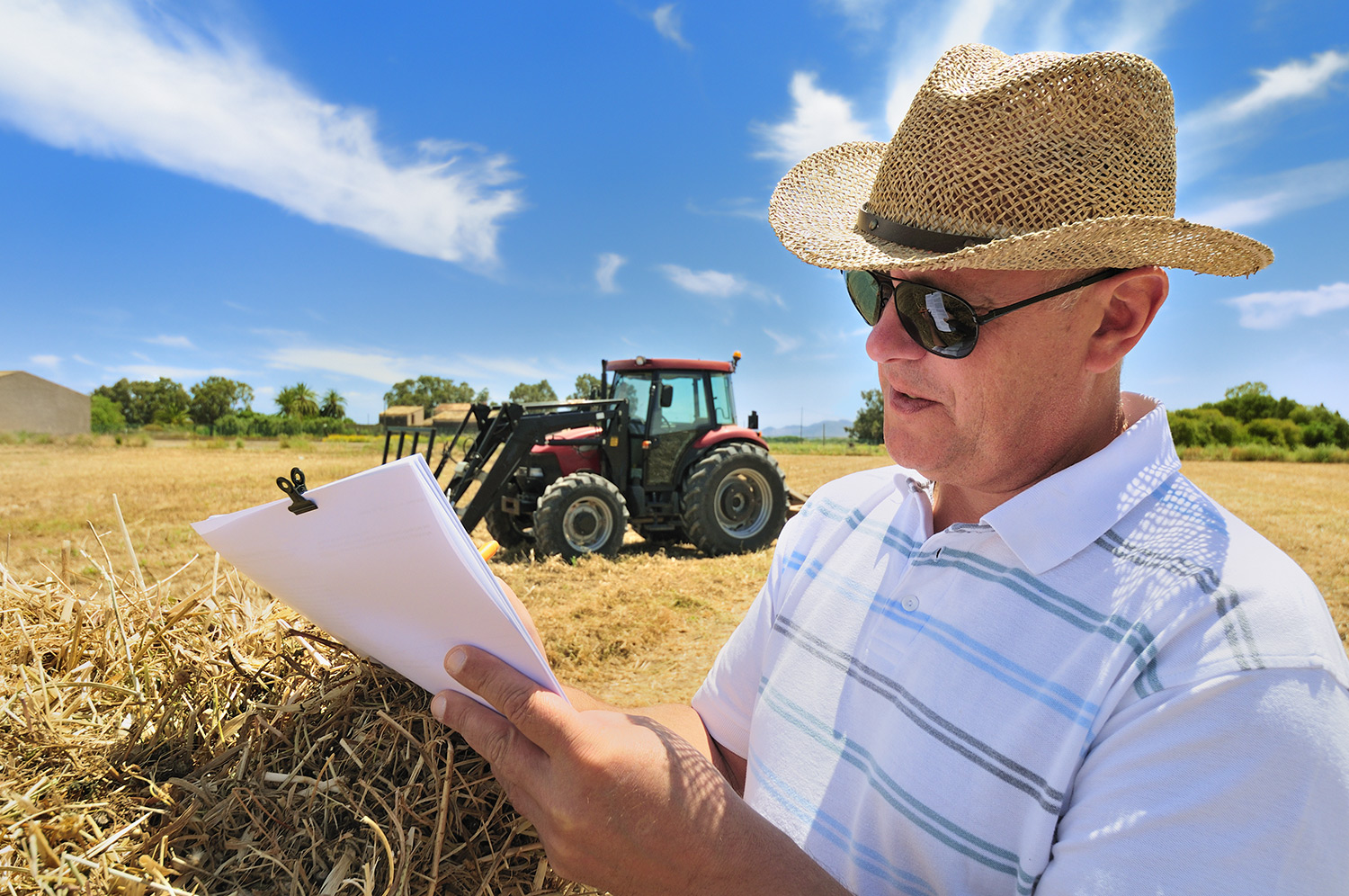 farmer working on documents in their field