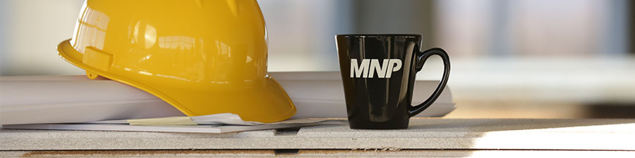MNP mug next to a construction worker hat.