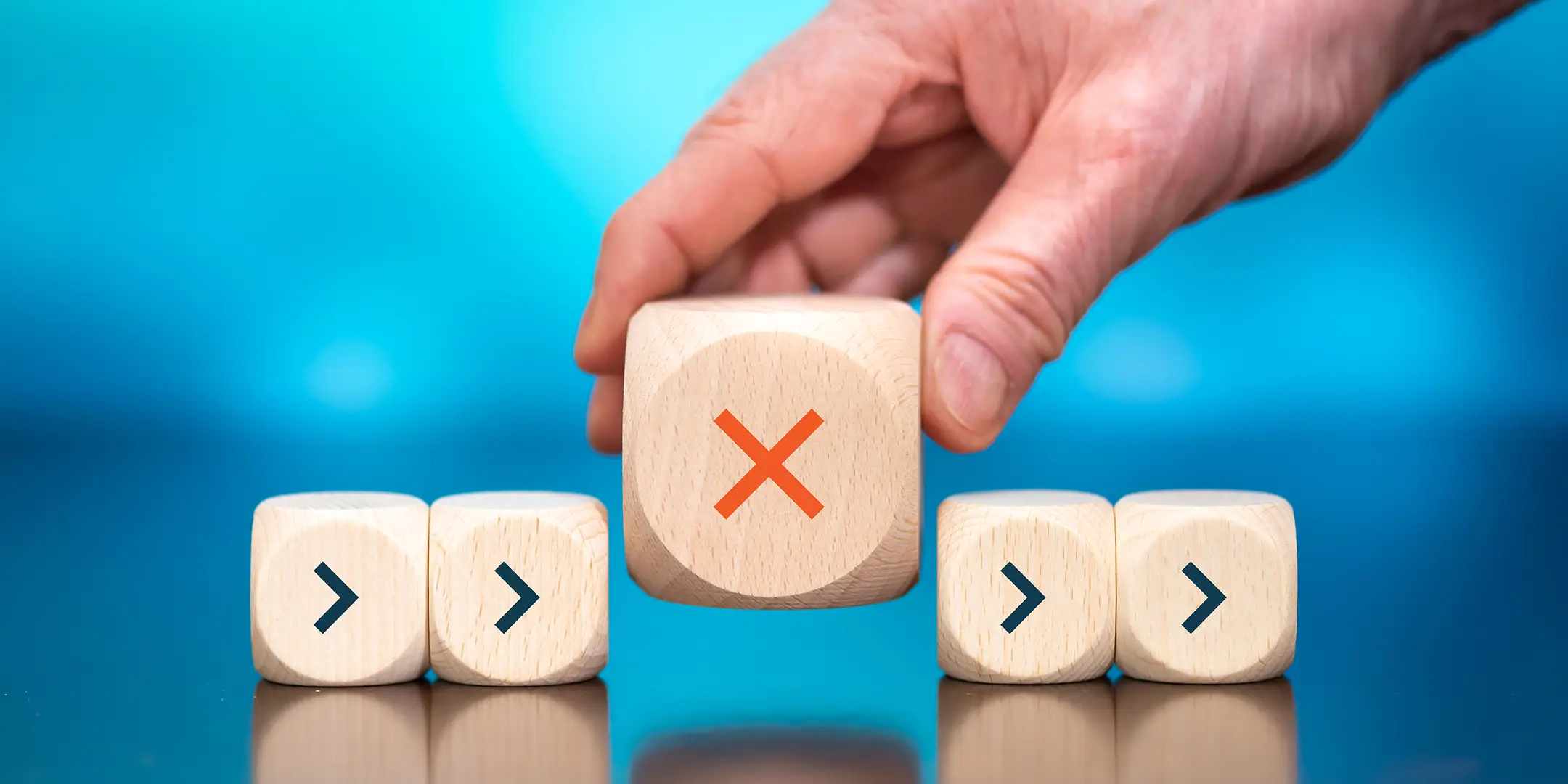 A person holding a wooden block with x