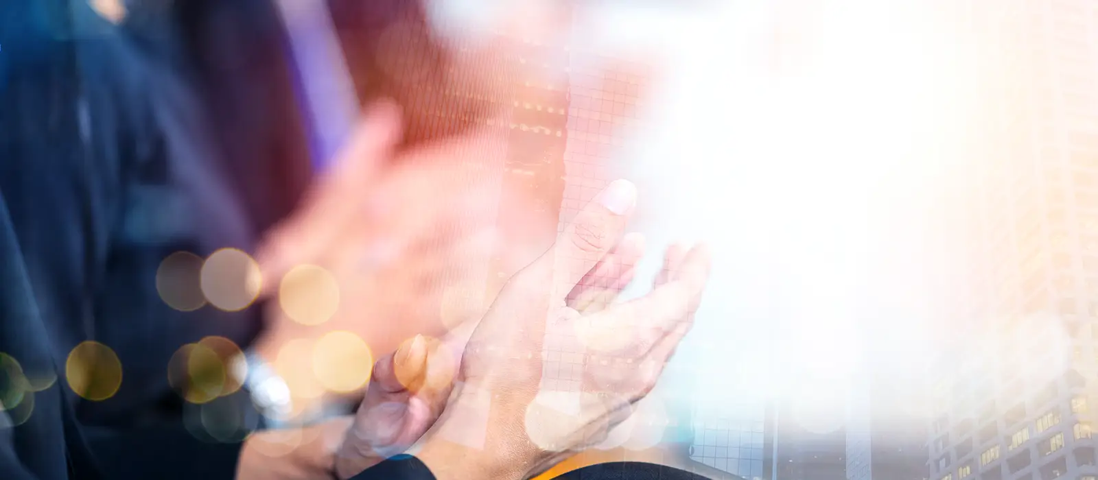 Business people applauding in front of a blurred background.