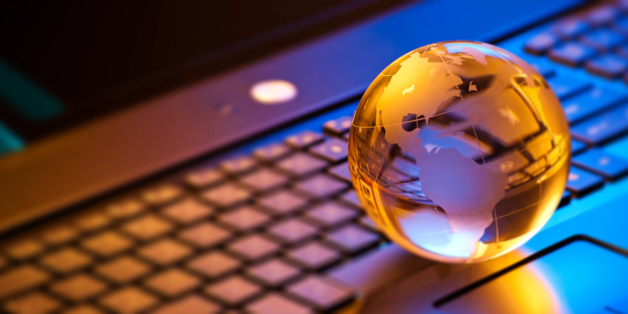 glass globe sitting on a laptop keyboard.