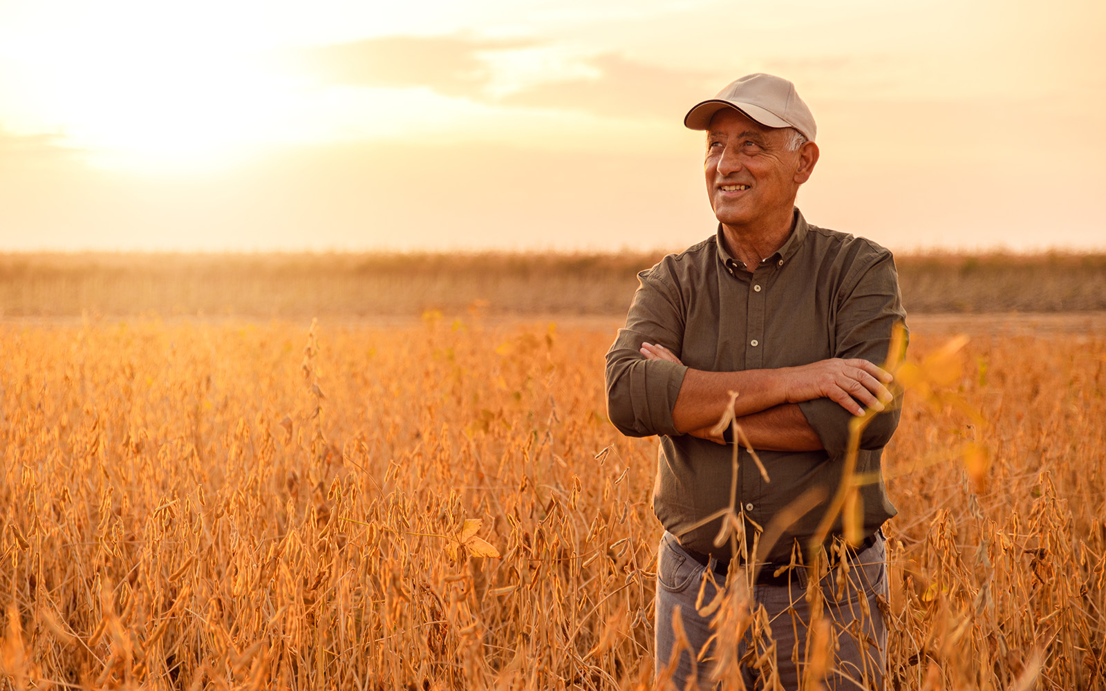 Man standing out in the field with arms crossed