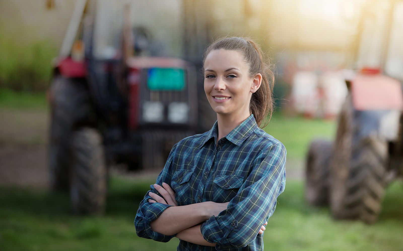 Woman standing in farm confidently with arms crossed