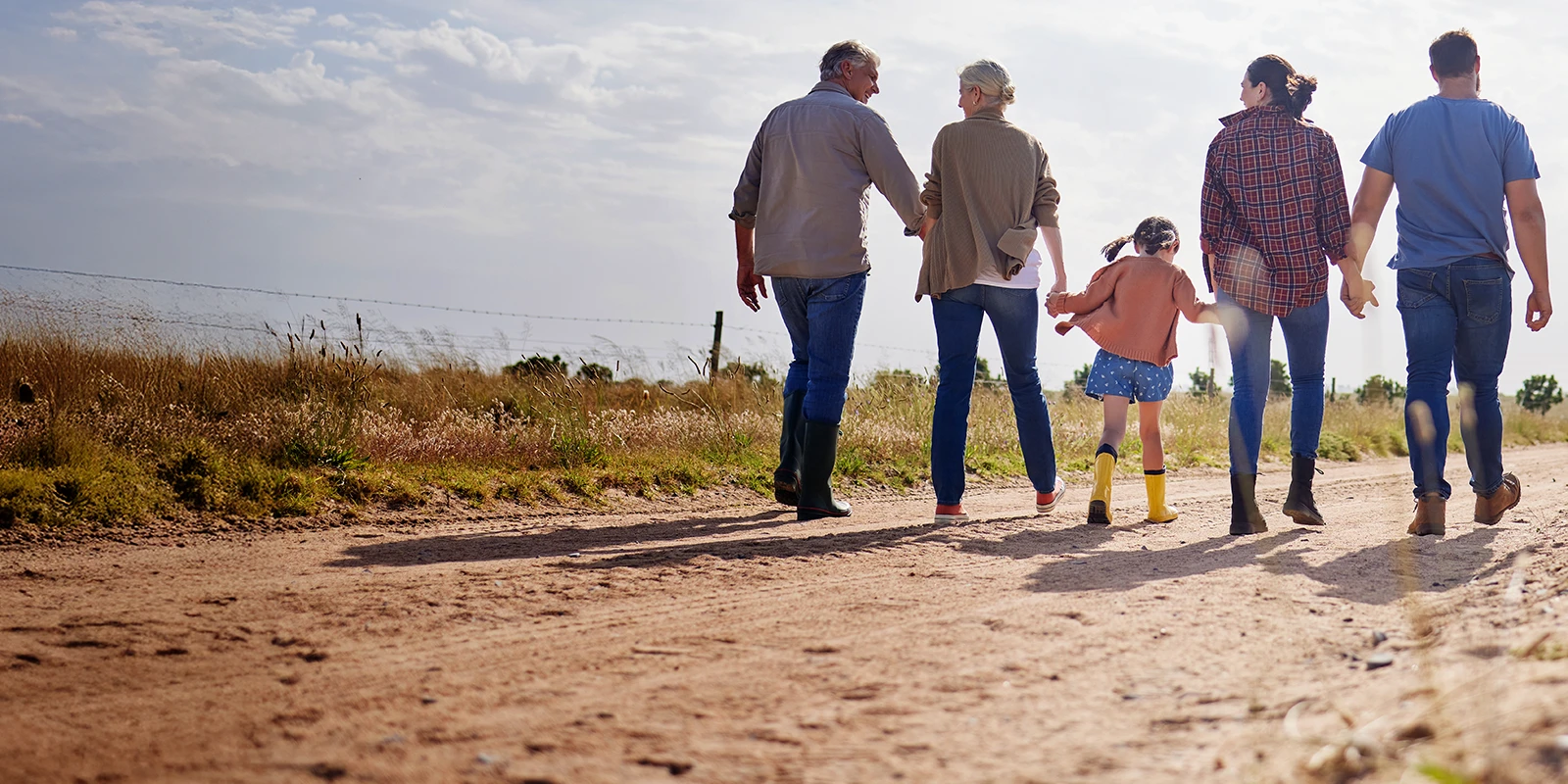 multi-generational farm family walking down a dirt road