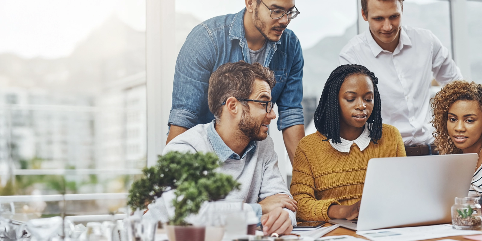 small business team gathered around computer looking for grants