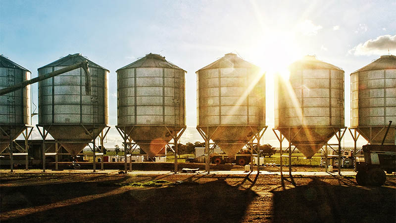 Grain silos with the sun shining in the sky