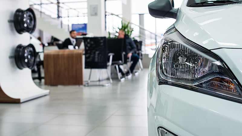 Headlights of a white car in a dealership
