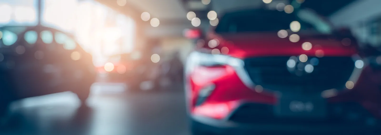 Blurred photo new red car parked in showroom car dealership