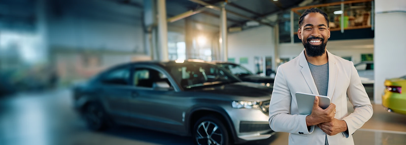 auto salesman smiling in a showroom
