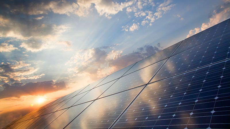 Close up view of a solar panel reflecting a cloudy sky