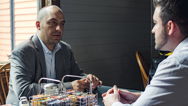 Two people sitting at a table in a diner
