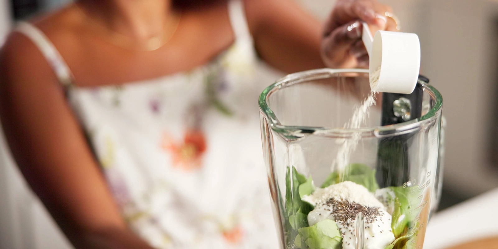 Young woman making a smoothie with protein powder