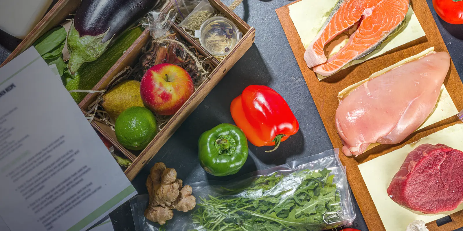 Concept de livraison de kits de repas avec divers plats sains, ingrédients alimentaires, viande, légumes, fruits, épices.