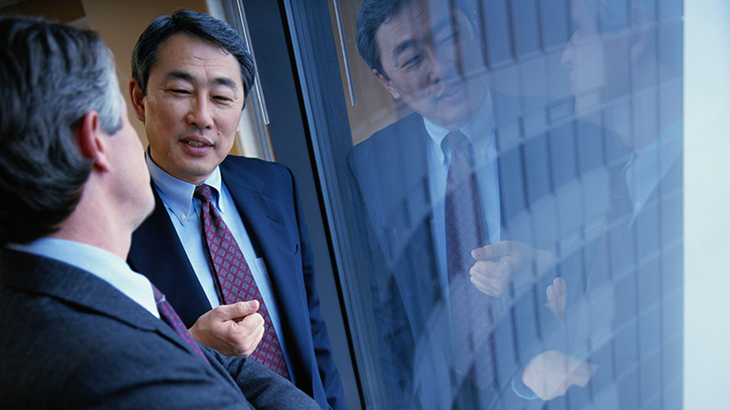 Two businessman talking near window