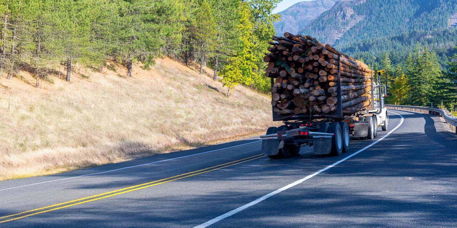 logging truck driving on the road through BC