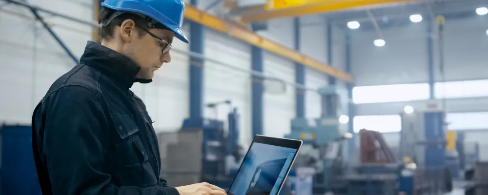 Ouvrier du bâtiment regardant sa tablette dans un entrepôt