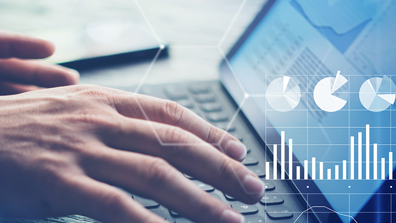 Mains tapant sur un ordinateur avec des diagrammes graphiques au premier plan