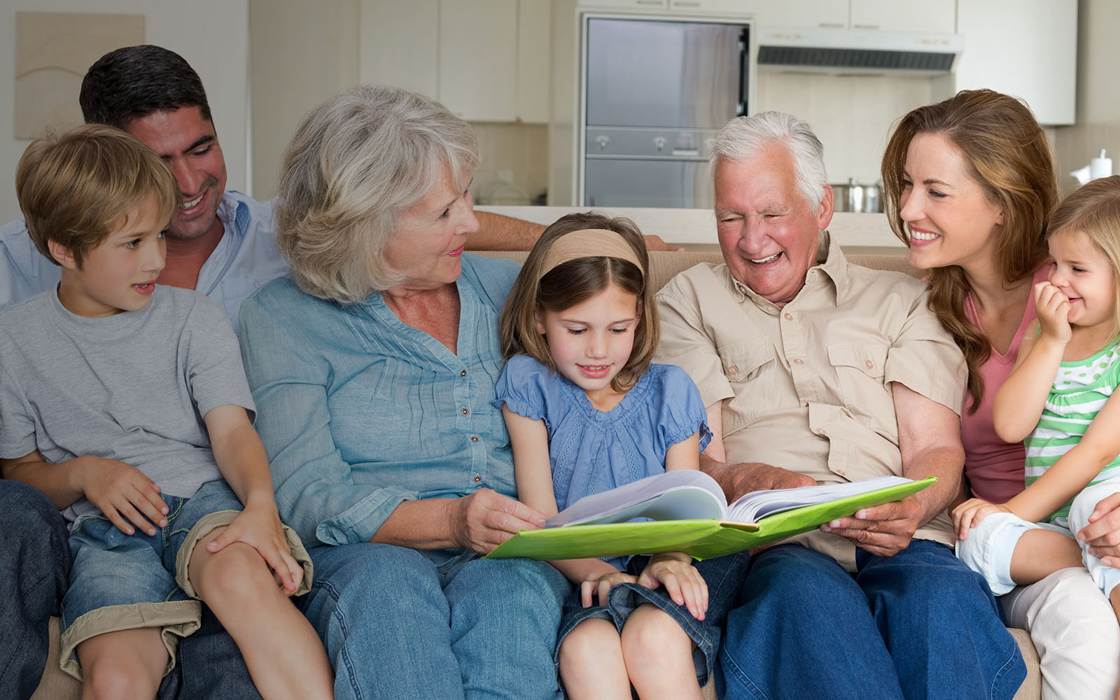 multi generational family on a couch looking at photos