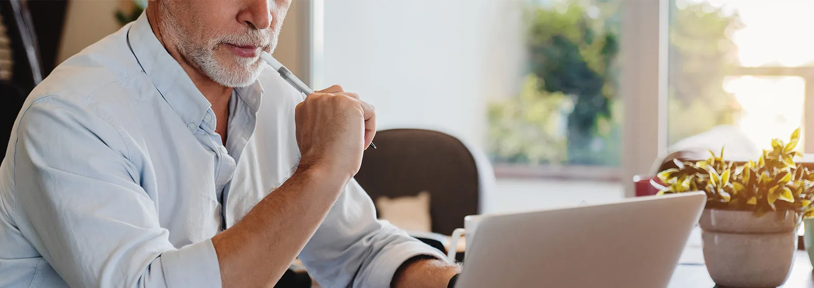 Man using a laptop to check documents.