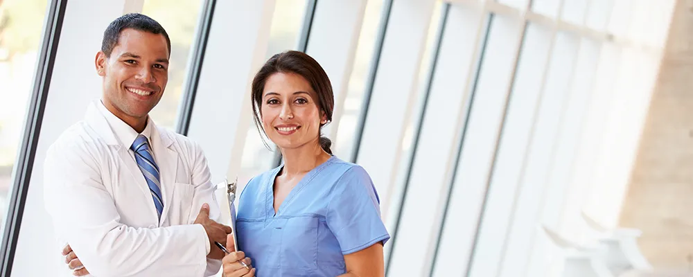 Two professionals standing together smiling