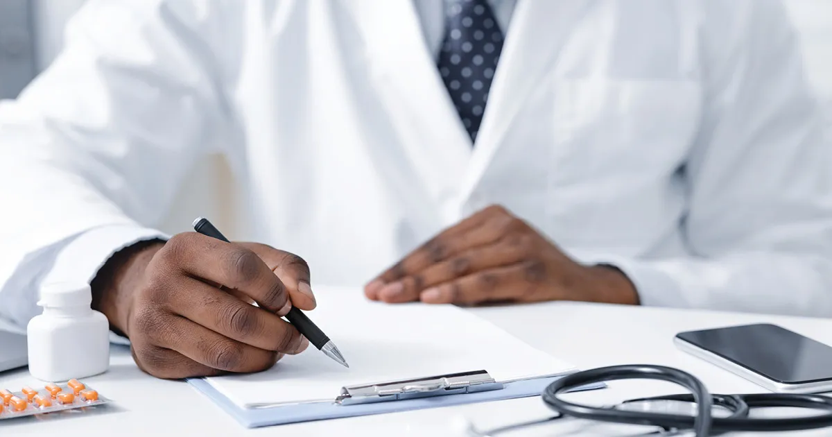 doctor writing notes on a clipboard