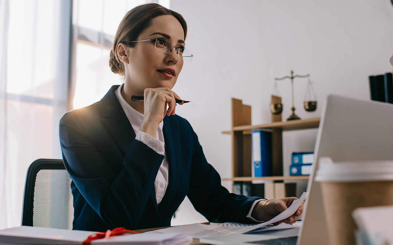 Young female lawyer at her desk and considers her next move in the cutthroat legal world