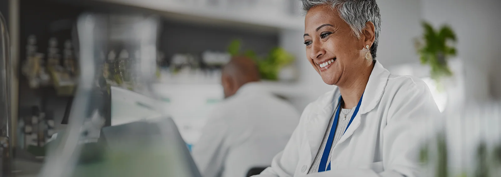 Professional woman sitting at at desk smiling while on laptop