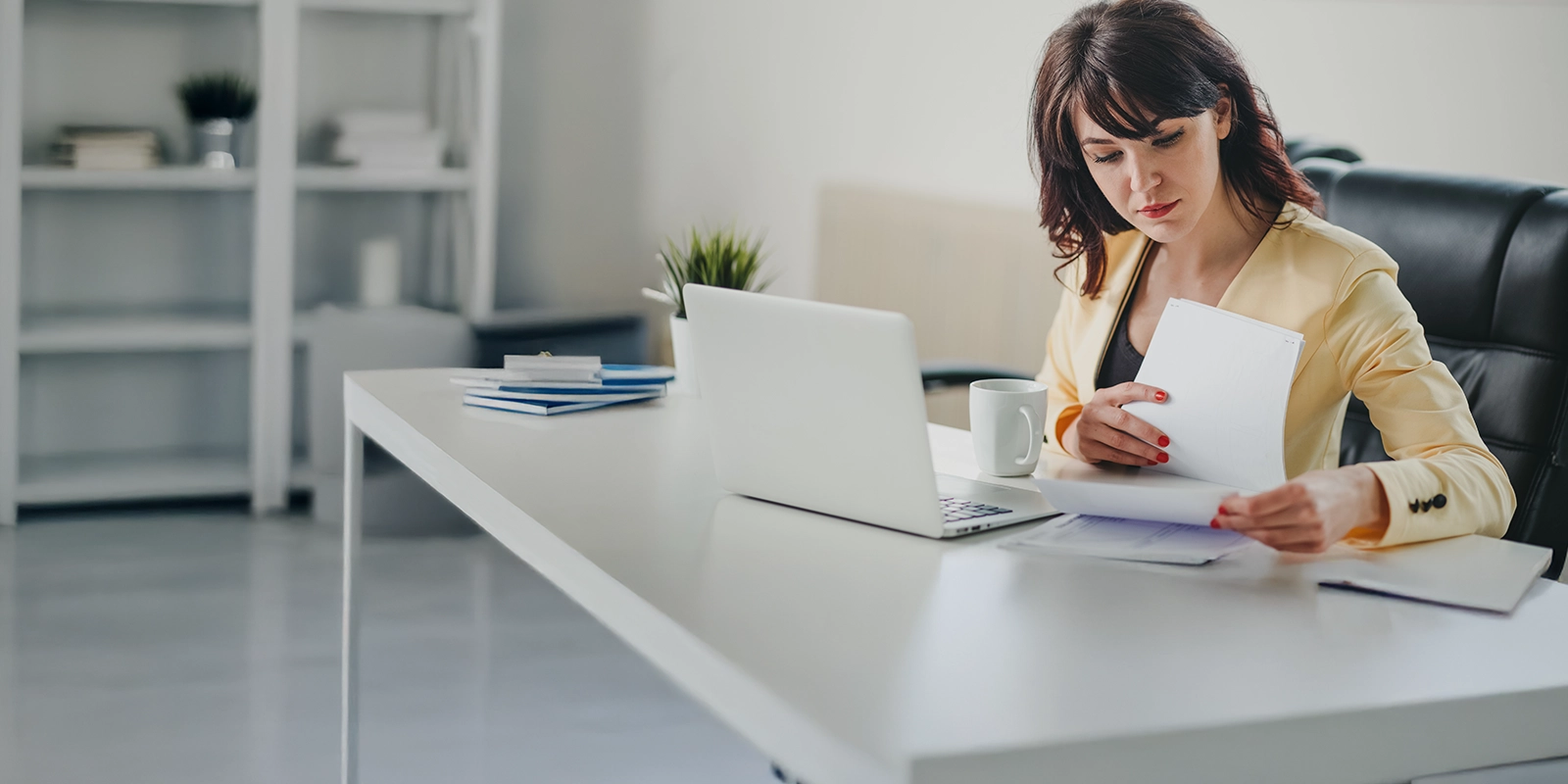 Femme d'affaires examinant des documents à son bureau