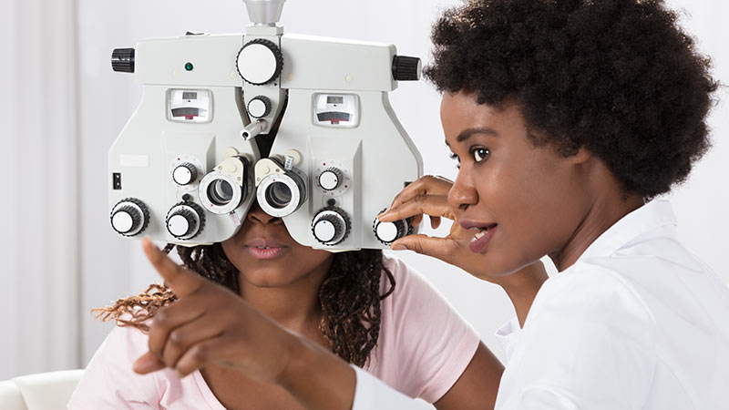 Optometrist doing an eye test on another person 