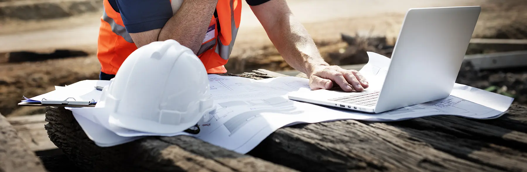 Construction worker looking at a laptop.