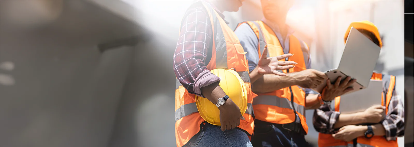 Construction workers collaborating over a laptop