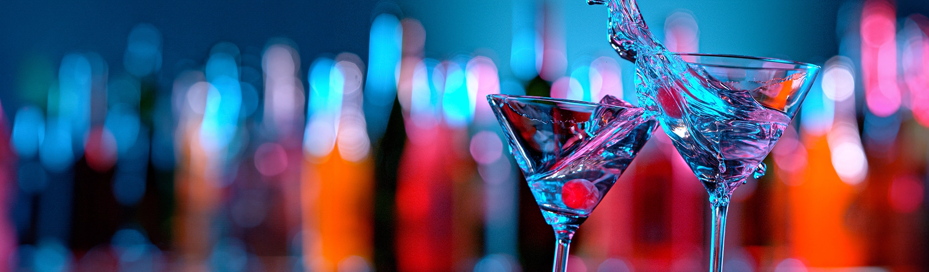 Two cocktail glasses with liquid splashing out